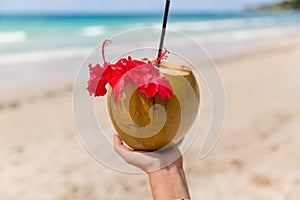 Coconut cocktail in a woman`s hand