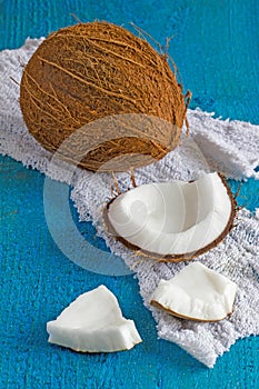 Coconut and coconut pieces with white cloth on wood background