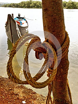 Coconut coir Rope on tree with reflection boat tired in river