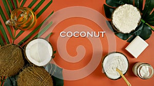 Coconut cosmetics with soaps, moisturizers and beauty products, tan background.