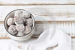 Coconut energy balls in a white cup. Copy space