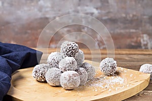 Coconut energy balls on a wooden tray, on a wooden table