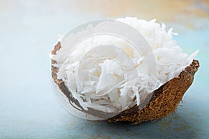 Coconut flakes in a shell on a blue background