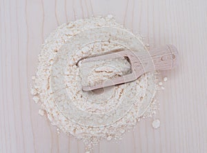 Coconut flour on wooden plate and wooden spoon