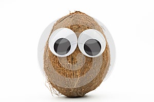 Coconut with googly eyes on white background