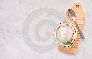 Coconut ice cream flavours in half of coconut setup on white stone background. Summer and Sweet menu concept