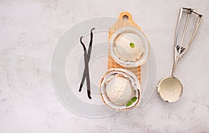 Coconut ice cream flavours in half of coconut setup on white stone background. Summer and Sweet menu concept