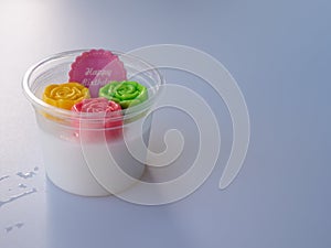 Coconut jelly sweet dessert with colorful rose shape in cup with happy birthday message