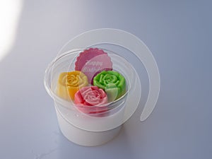 Coconut jelly sweet dessert with colorful rose shape in cup with happy birthday message
