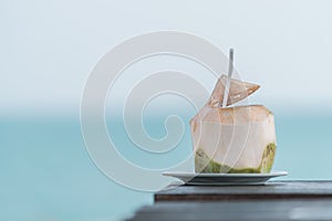 Coconut juice on table in blurred beach background