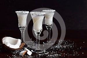 Coconut liqueur in glass with broken coco. Delicious Pinacolada milk cocktail with rum. Alcohol drink liquor. Copy space