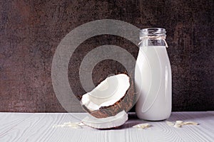 Coconut milk in a vintage bottle with ingredients against a dark background