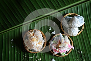 coconut muchkins, Sticky morsels, Rice flour mixed with toddy palm and shredded coconut Thai dessert on the green coconut leaf