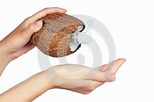 Coconut oil bottle and cap in a hand on white isolate