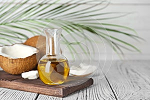 Coconut and oil in bottle on wooden table. Healthy cooking