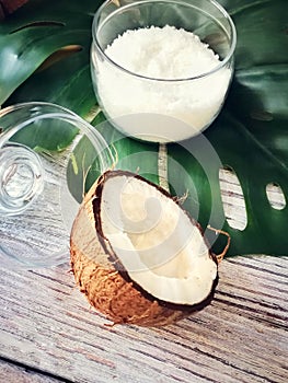 Coconut oil and flakes, tropical leaves and fresh coconuts