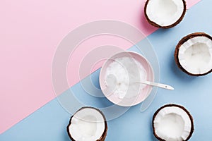 Coconut oil with fresh coconuts fruit on minimal pastel background top view. Natural and organic beauty cosmetic. Flat lay.