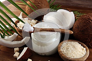 Coconut oil with fresh nut Coconut products with fresh coconut, Coconut flakes, coconut spa oil and palm leaves on rustic