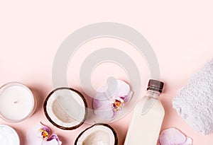 Coconut oil and halves of fresh coconut on a pink background. Hair care spa concept