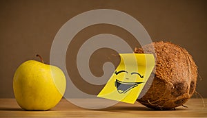 Coconut with post-it note laughing on apple