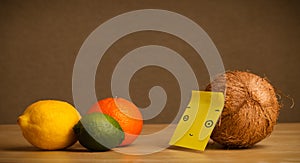 Coconut with post-it note looking at citrus fruits