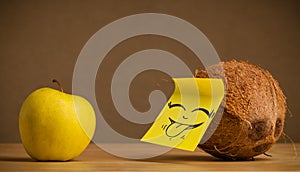 Coconut with post-it note sticking out tongue to apple