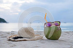 Coconut refreshment exotic juice with straw on the beach