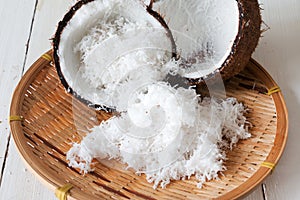 Coconut shell and Freshly grated coconut on bamboo tray