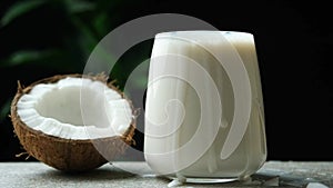 Coconut slices falling into a glass of coconut milk slow motion