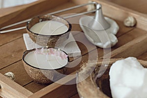 Coconut Spa concept: coconut, coconut oil and candle with the scent of coconut on a wooden table. aromatherapy concept