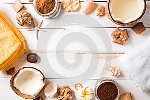 Coconut, spa products, coffee scrub, towels and seashells on white background