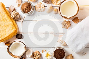 Coconut, spa products, coffee scrub, towels and seashells on white background