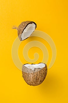 Coconut on yellow colored background, minimal flat lay style.