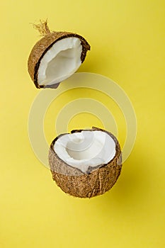 Coconut on yellow colored background, minimal flat lay style.