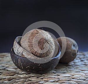 Coconuts bowls and whole cocos on the table.