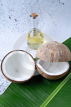 Coconuts and Coconut oil product organic for cosmetic natural care health in a bottle put on a white table