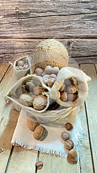 Coconuts on an oak table surrounded by nuts photo