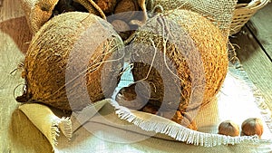 Coconuts on an oak table surrounded by nuts photo