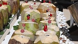 Coconuts are prepared on the table for making exotic cocktails