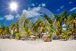 Cocos beach bar on a beach with white sand and palms on a sunny day, Isla Mujeres island, Caribbean Sea, Cancun, Yucatan, Mexico