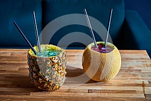 Coctail drinks with ice served in melon and pinapple