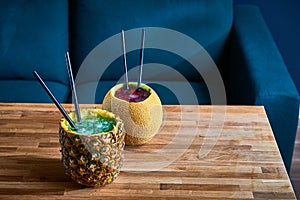 Coctail drinks with ice served in melon and pinapple