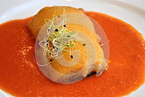 Cod au gratin with garlic muslin on tomato sauce photo