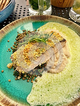 cod fillet in breadcrumbs, crispy breading on fish fillet, lentils, celery puree, parsley sauce, dinner in a restaurant, cod photo