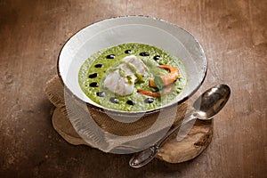 cod fillet and shrimp over zucchini cream on wood background