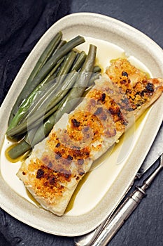 Cod fish with corn bread and green beans on dish