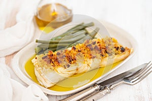 Cod fish with corn bread and green beans on dish
