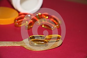 Cod liver fish oil omega 3 gel capsules on red background. Healthcare concept