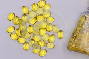 Cod liver oil capsules bottle with some spilled over