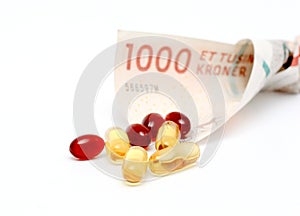 Cod liver oil omega 3 gel capsules with 1000 danish kroner currency bank note